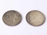 deux pièces britanniques, l'une en argent et l'autre en argent, posées sur une surface blanche