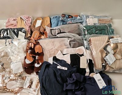 beaucoup de vêtements et de chaussures posés sur une table