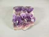 cristaux améthoraux violets sur une surface blanche, avec un fond blanc