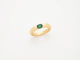une bague en or avec une pierre verte au centre