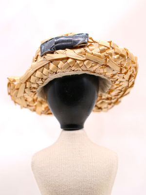 un gros plan d'un chapeau de paille sur une tête de mannequin