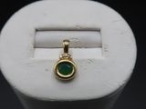 an image of a gold and green stone pendant on a white ring