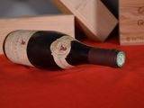 a bottle of wine sitting on a table next to a wooden box