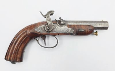 un vieux pistolet avec une poignée en bois sur une surface blanche