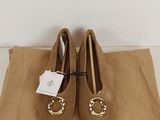 a pair of brown shoes sitting on top of a brown bag
