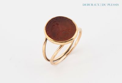 a close up of a gold ring with a coin on it
