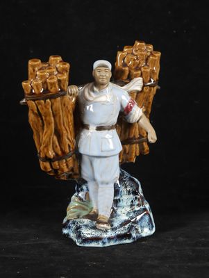 figurine of a man holding a bunch of logs on a black background