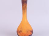 un petit vase posé sur une surface blanche