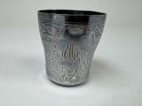 une coupe en argent posée sur une table, sur laquelle figure un monogramme