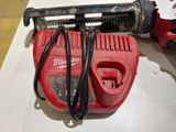 a red corded drill and a corded hammer on a table