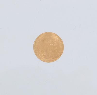 gros plan d'une pièce d'or sur une surface blanche