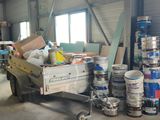 several cans of paint are stacked on a trailer in a warehouse
