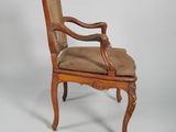 an old wooden chair with a brown seat and a brown cushion