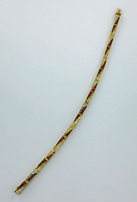 un gros plan d'un bracelet en or et diamants posé sur une surface blanche