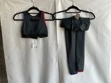two pieces of clothing hanging on a hanger next to a white sheet