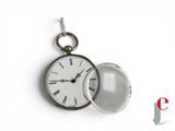 a small pocket watch with a chain hanging from it ' s side