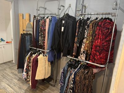 de nombreux vêtements suspendus à un portant dans une pièce