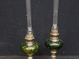 paire de bougeoirs en verre vert rehaussés de touches dorées sur fond noir