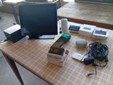une table sur laquelle se trouvent un ordinateur, un écran et d'autres appareils électroniques