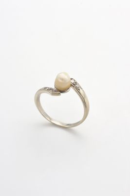 une image d'une bague en perles et diamants sur fond blanc