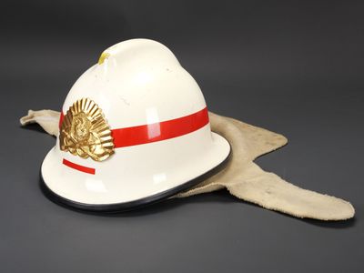 un vieux casque de pompier blanc à rayures rouges et blanches