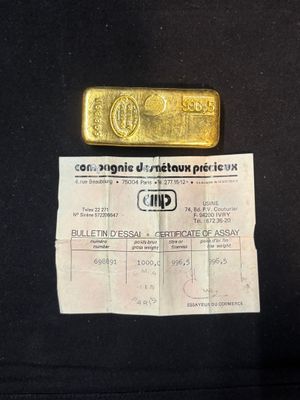 a piece of gold on a black shirt with a price tag