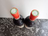 two bottles of wine sitting next to each other on a table