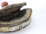 a small wooden box with a red bead in it