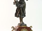une statue représentant une femme tenant un bâton et une horloge