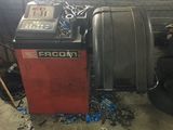 une machine qui se trouve dans un garage, à côté d'un tas de pneus