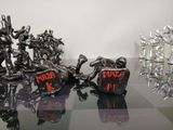 several metal figurines are sitting on a glass table