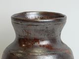 a brown vase sitting on a table with a white background