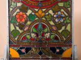 an old stained glass panel with flowers and leaves on it