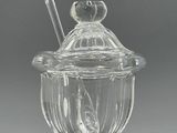 un bocal en verre transparent avec une cuillère et un repose-cuillère posé dessus