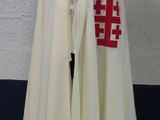 a white cape with a red cross on it