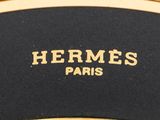 a close up of a black and gold belt with the word hermes paris on it