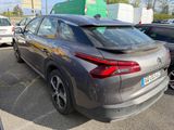 the rear end of a gray car parked in a parking lot