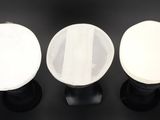 three white and black lamps sitting on top of a black table