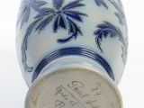 a blue and white vase sitting on a white surface