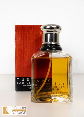 l'image d'un flacon de parfum posé à côté d'une boîte
