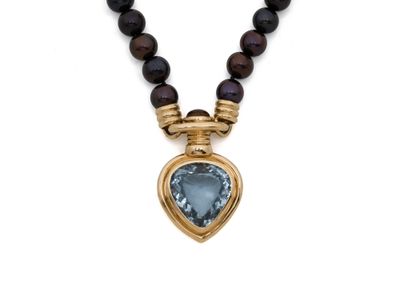un gros plan sur un collier orné d'un pendentif en forme de cœur