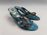 une paire de sandales en cuir bleu ornées de boucles dorées au niveau des orteils