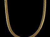 a gold chain necklace on a black background