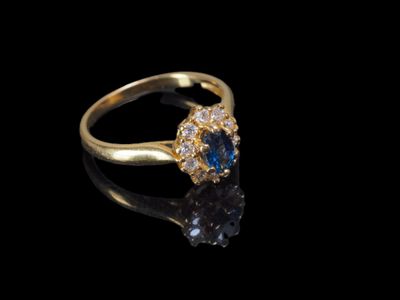 gros plan d'une bague en or avec des diamants bleus et blancs