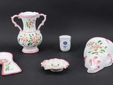 une petite collection d'objets en porcelaine posés sur un fond noir