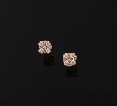 a pair of diamond stud earrings on a black surface