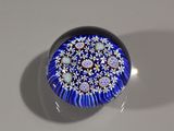 un objet en verre bleu et blanc posé sur une surface blanche