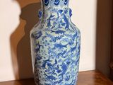 un vase bleu et blanc posé sur une table en bois