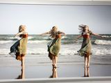 une photo de trois femmes en train de danser sur la plage
