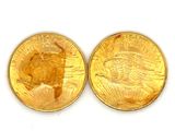 two gold coins sitting side by side on a white surface